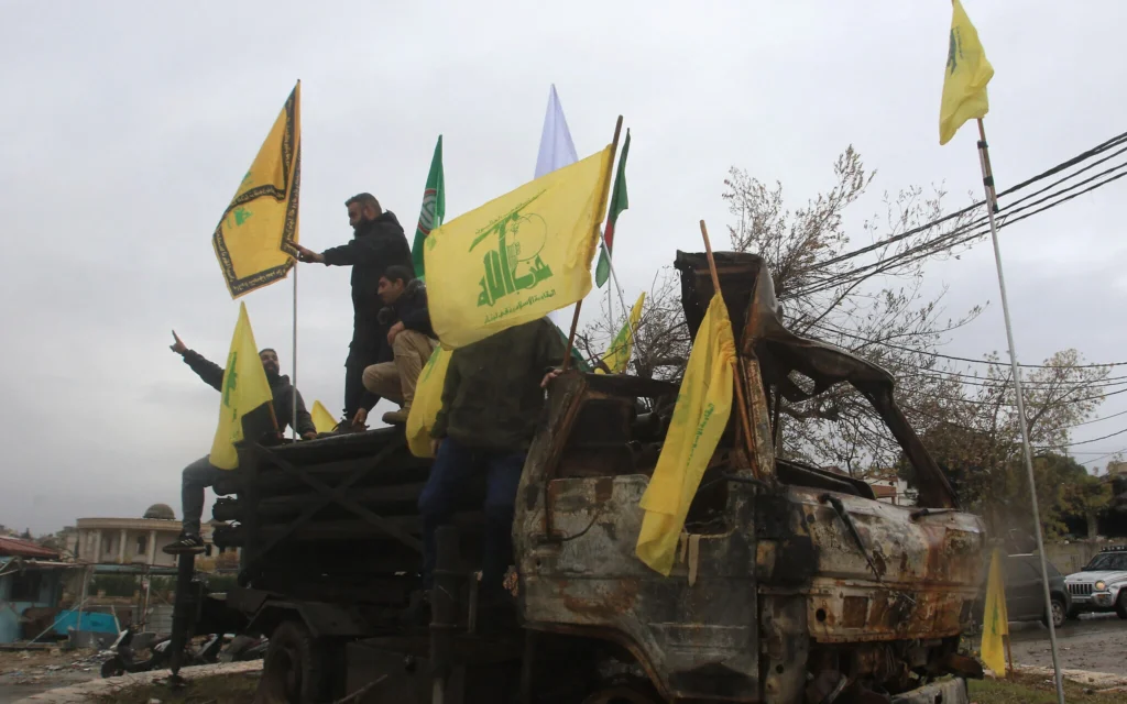 Bandiere di Hezbollah sventolano su macerie e detriti dopo aver subito pesanti bombardamenti.